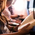 Frau liest ein Buch im Flugzeug