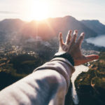 Mann streckt Hand aus vor Kapstadt-Panorama