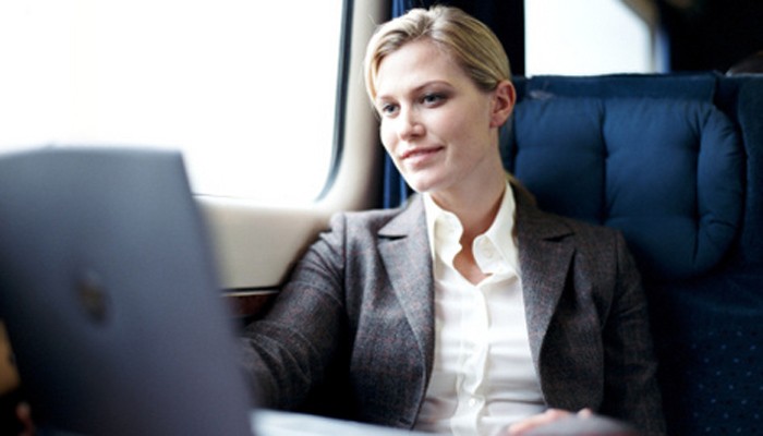 Geschäftsfrau im Zug mit Notebook