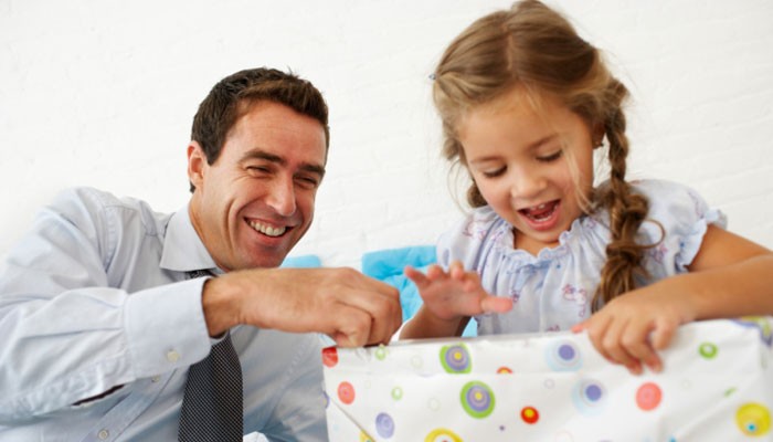 Geschäftsmann freut sich mit Tochter über Geschenk