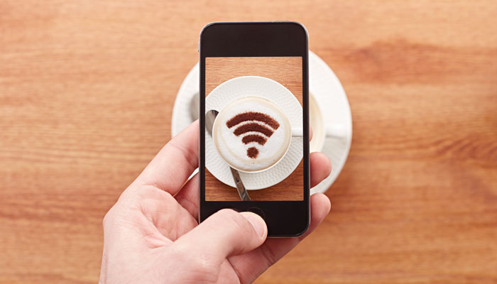 Smartphone mit WLAN-Icon und Kaffeetasse
