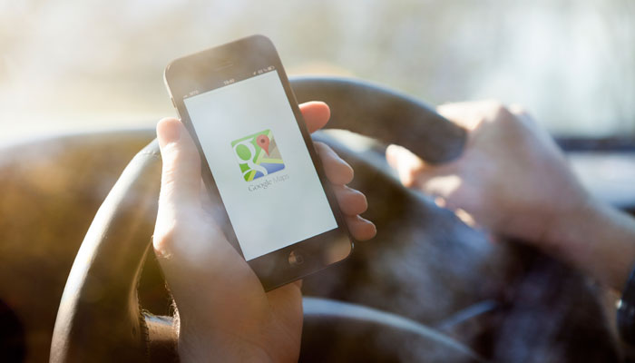 Smartphone im Auto mit Google Maps Logo