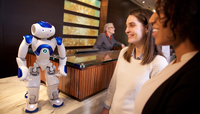 Gäste mit IBM-Roboter "Connie" an Rezeption