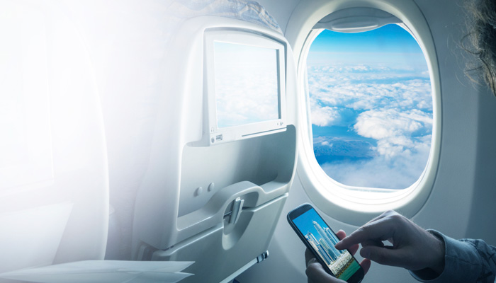 Passagier mit Smartphone im Flugzeug