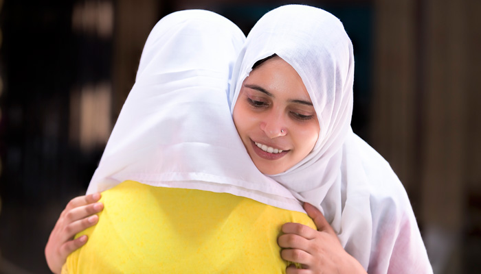 Zwei muslimische Frauen umarmen sich
