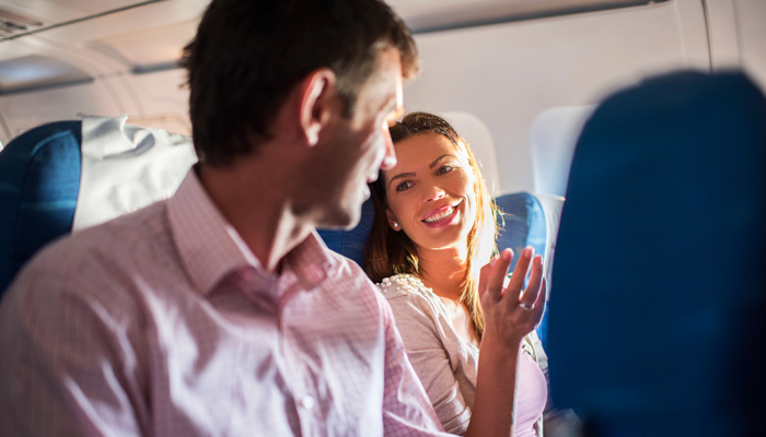 Mann und Frau unterhalten sich im Flugzeug