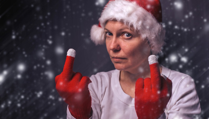 Frau mit Weihnachtsmütze und Mittelfinger