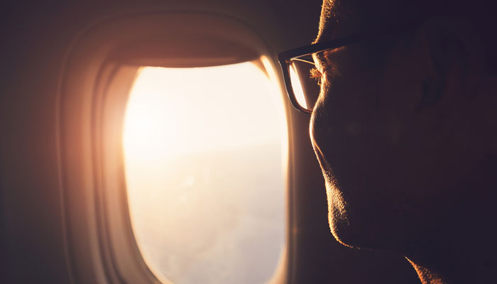 Mann schaut aus Flugzeugfenster