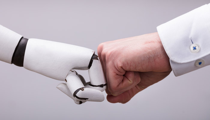 Roboter und Geschäftsmann fausten sich zu; Foto: iStock.com/AndreyPopov