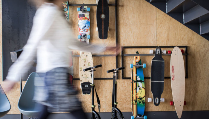 Frau vor Wand mit Skateboards; Foto: Schani Hotels