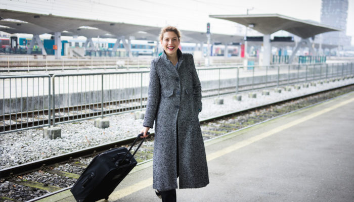 Geschäfsfrau mit Koffer auf Bahnsteig; Foto: iStock.com/kovaciclea