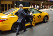 Street of Manhattan. Elegant man getting into yellow cab