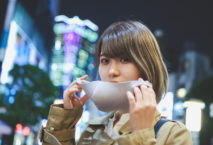 Japanerin setzt gerade ihre Maske auf. Foto kyonntra/iStock